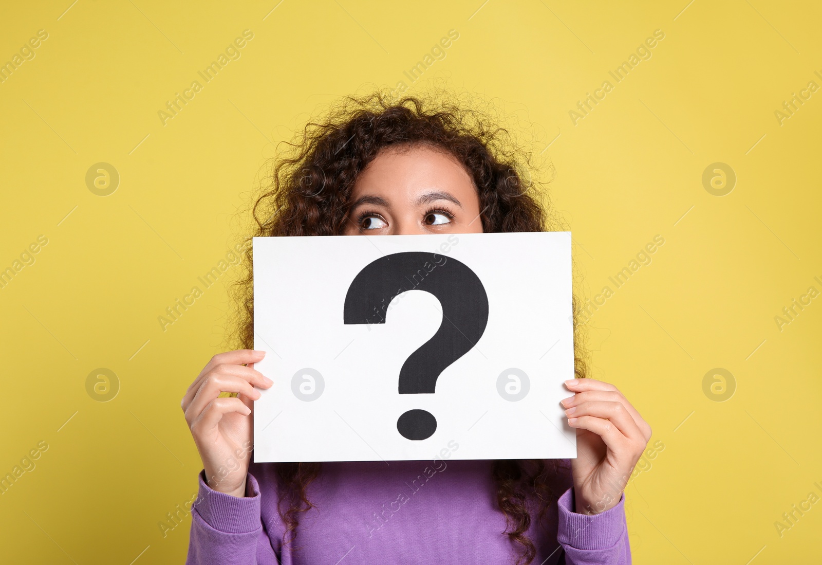 Photo of African-American woman with question mark sign on yellow background