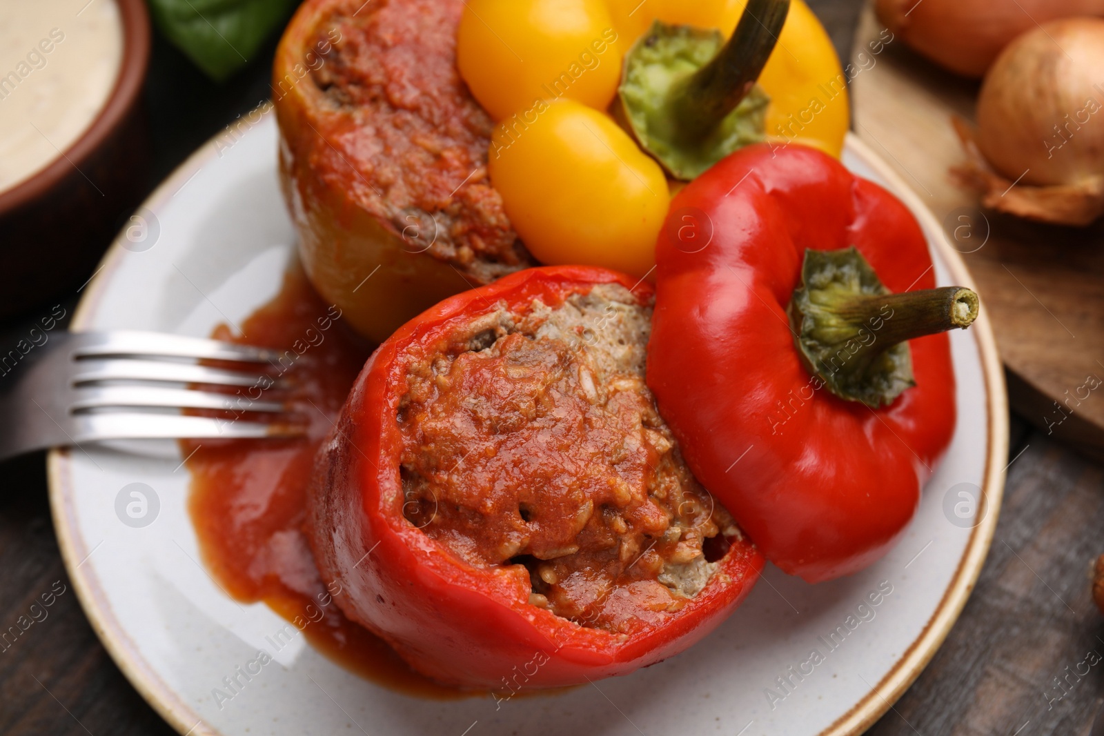 Photo of Delicious stuffed bell peppers served on wooden table, closeup