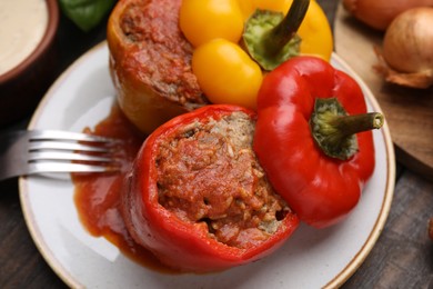 Photo of Delicious stuffed bell peppers served on wooden table, closeup