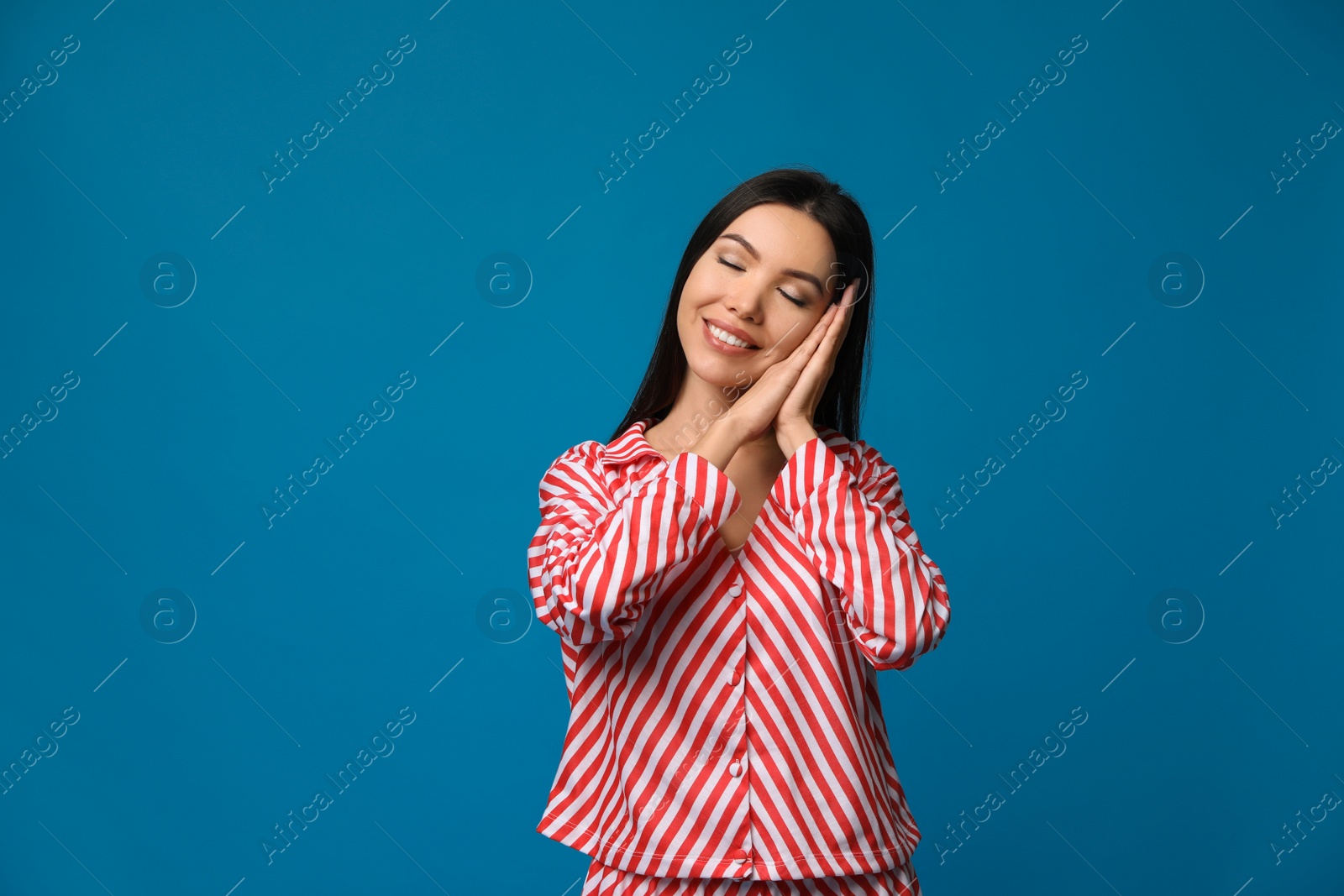Photo of Beautiful Asian woman wearing pajamas on blue background. Bedtime
