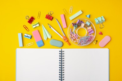 Photo of Flat lay composition with notebook and different school stationery on yellow background. Back to school