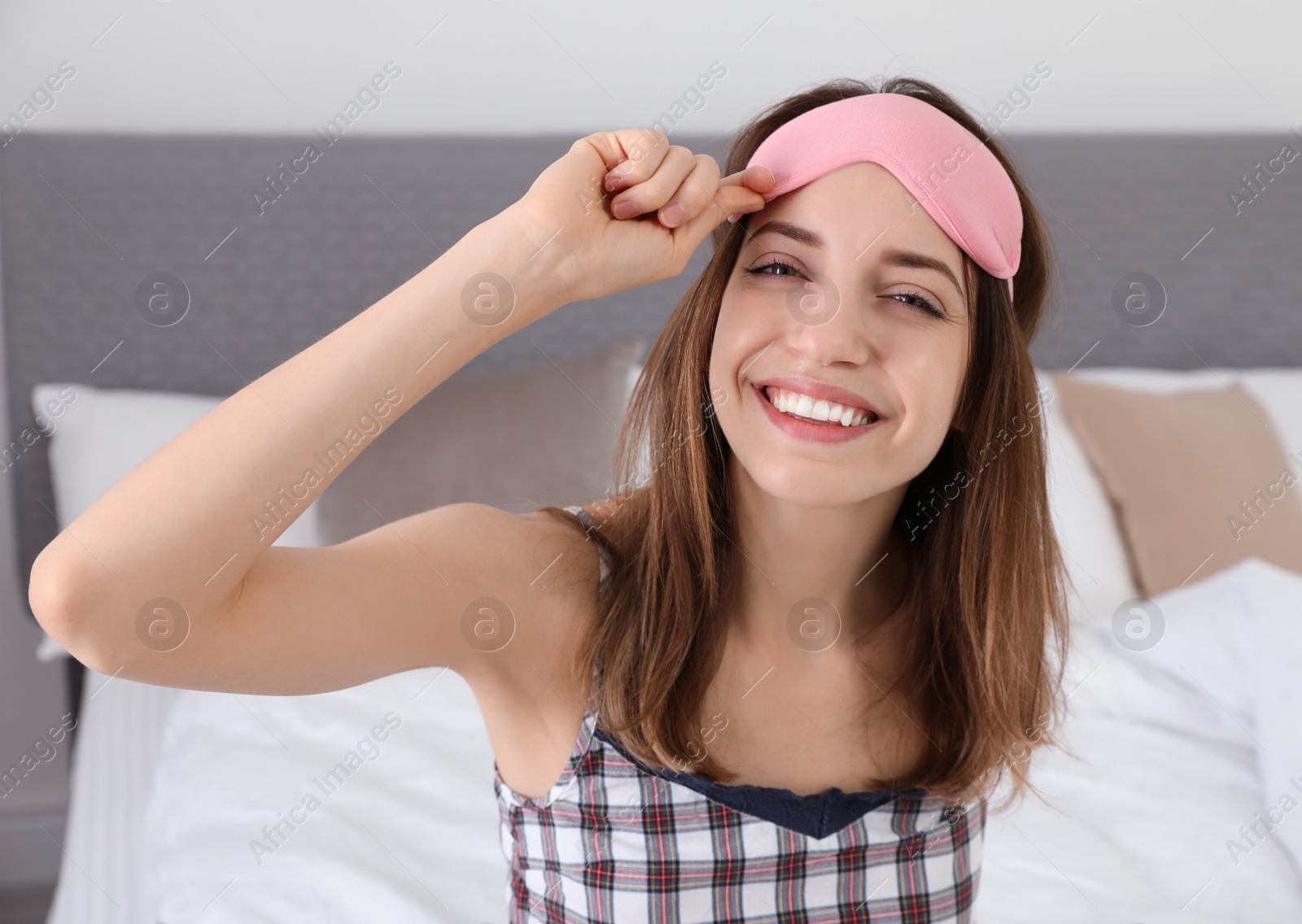 Photo of Beautiful woman wearing pajamas and sleep mask indoors. Bedtime