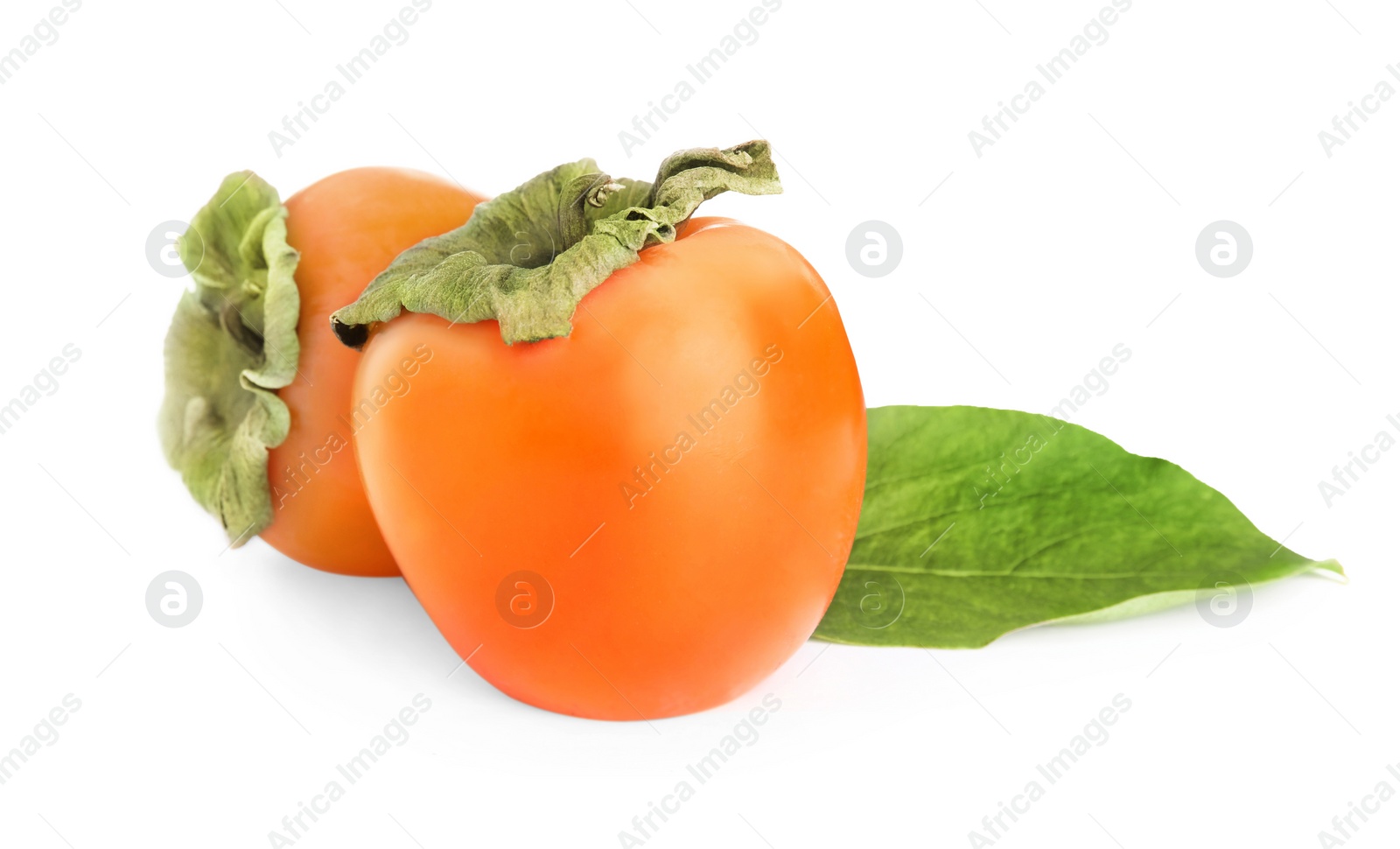 Photo of Delicious persimmons and green leaf isolated on white