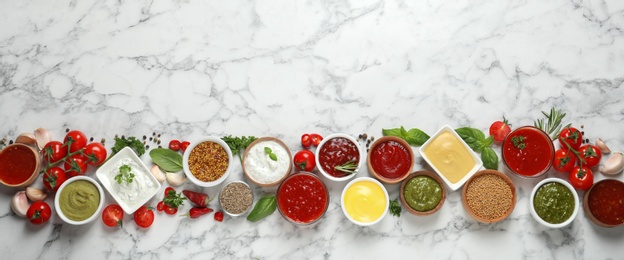 Photo of Flat lay composition with different sauces and space for text on marble background