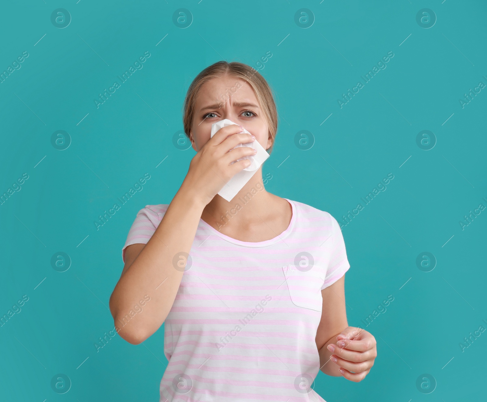 Photo of Young woman suffering from allergy on turquoise background