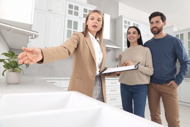 Photo of Real estate agent showing new apartment to couple