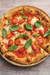 Photo of Delicious Margherita pizza on wooden table, top view