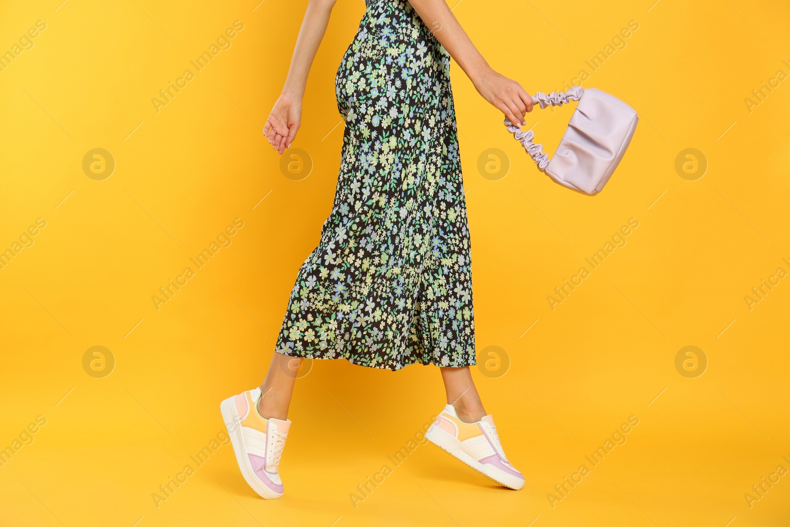 Photo of Woman with stylish bag on yellow background, closeup
