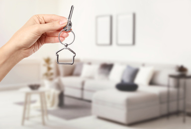 Image of Woman with key in new modern apartment, closeup