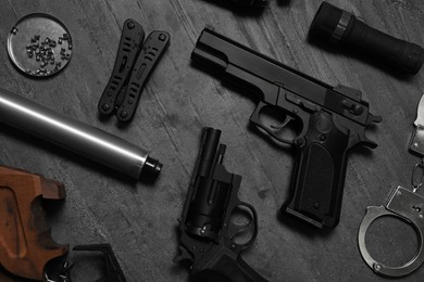 Photo of Flat lay composition with different guns on dark table