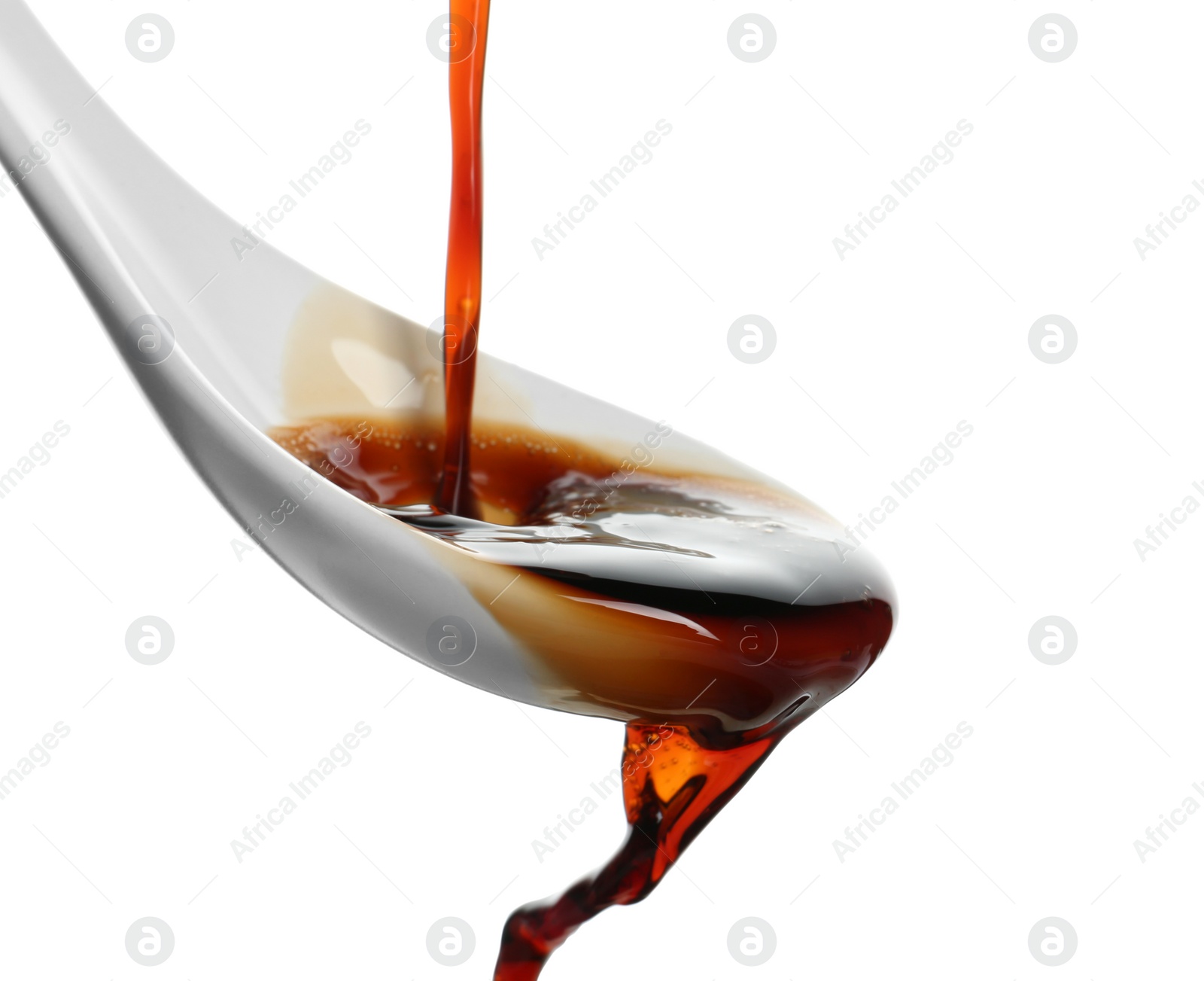 Photo of Pouring soy sauce into spoon against white background