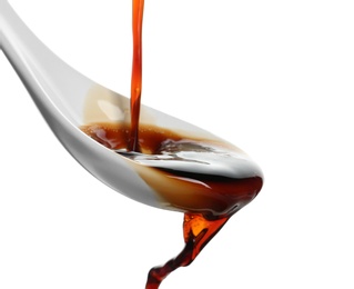 Photo of Pouring soy sauce into spoon against white background