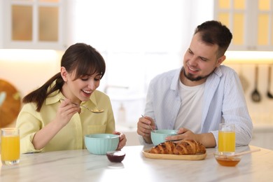 Happy couple having tasty breakfast at home