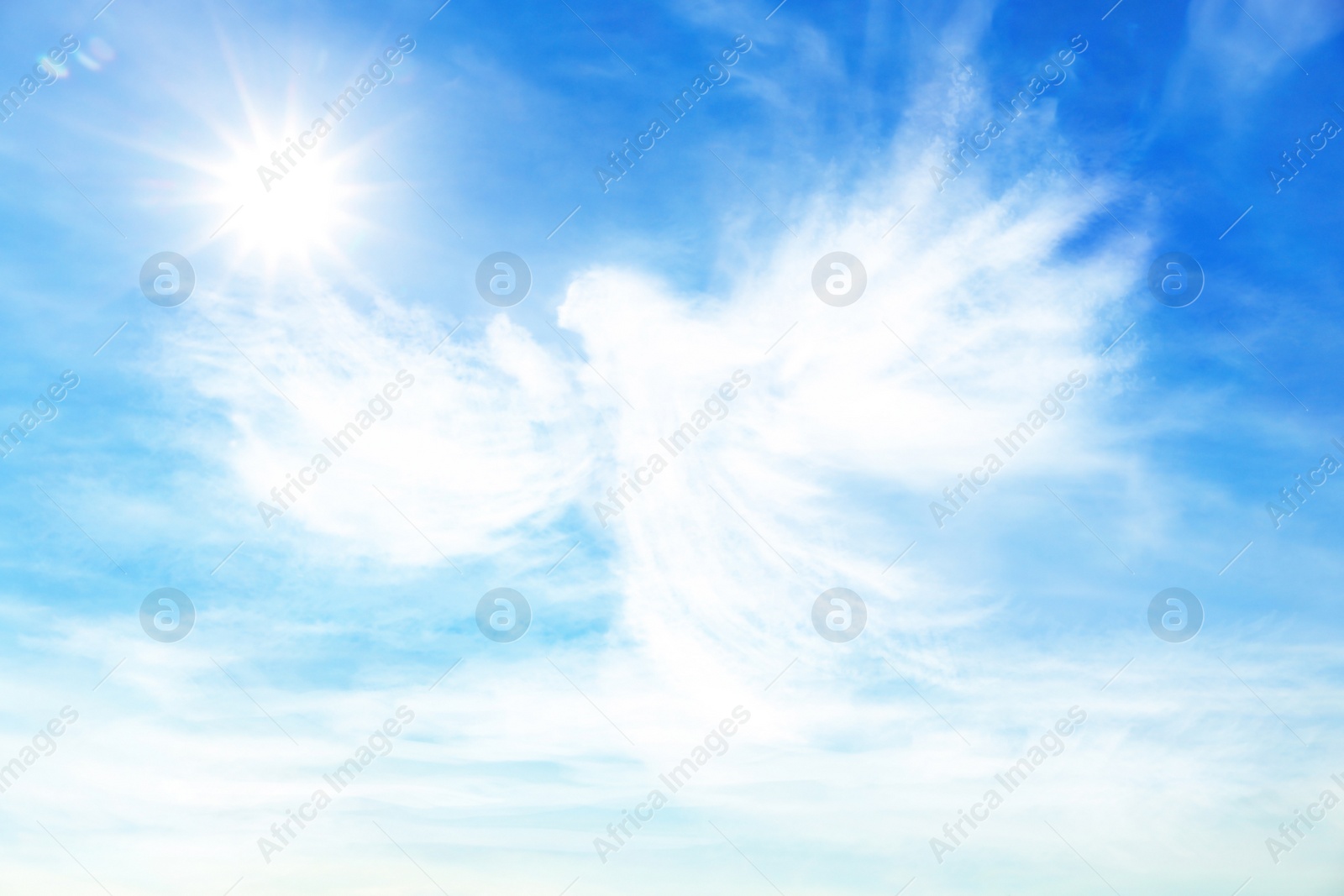 Image of Silhouette of angel made of clouds in blue sky 