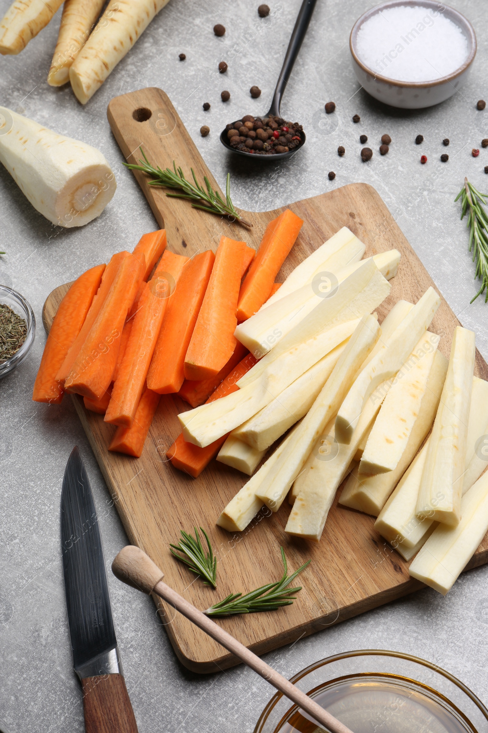 Photo of Composition with parsnips, carrots and other products on light grey table