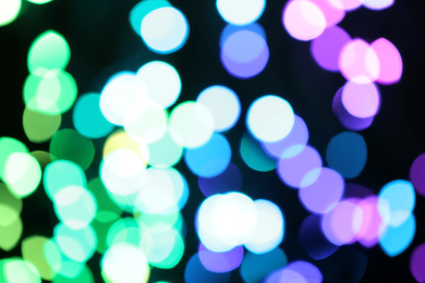 Blurred view of colorful lights on black background. Bokeh effect