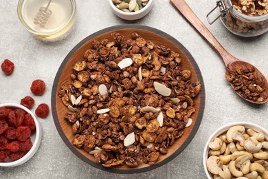 Photo of Tasty granola served with nuts and dry fruits on light grey table, flat lay