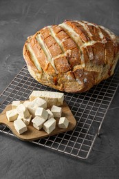 Photo of Freshly baked bread with tofu cheese on black table