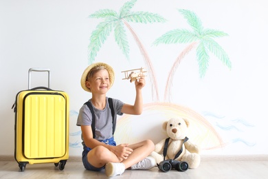 Photo of Adorable little child playing with toy airplane indoors