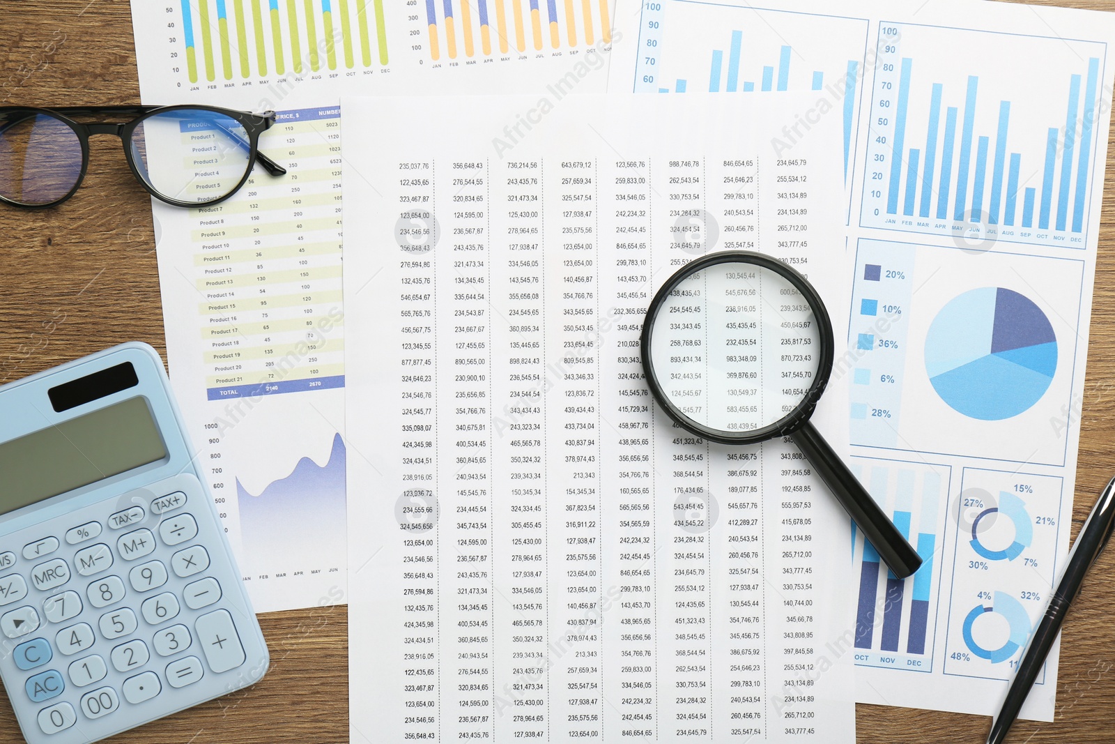 Photo of Accounting documents, magnifying glass, stationery and glasses on wooden table, top view