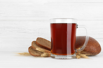 Composition with delicious kvass, spikes and bread on white table