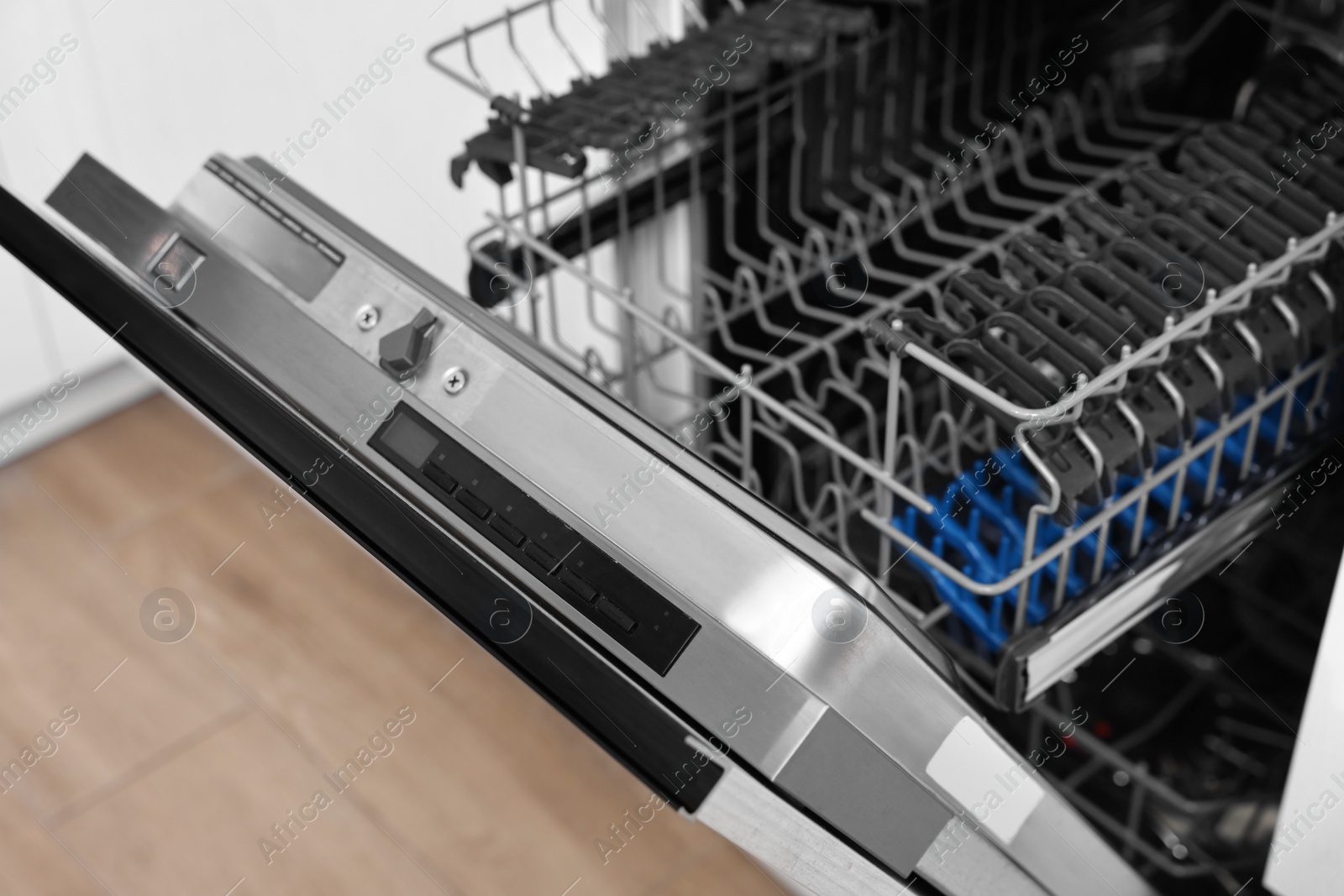 Photo of Built-in dishwasher with open door indoors. Home appliance