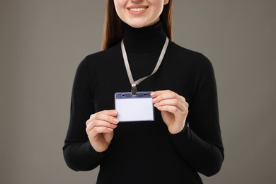 Photo of Woman with blank badge on grey background, closeup