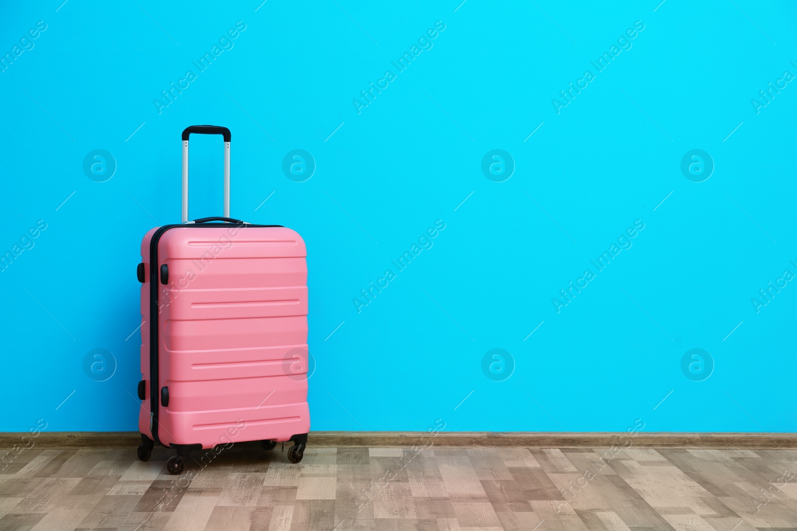 Photo of Packed suitcase near color wall with space for text