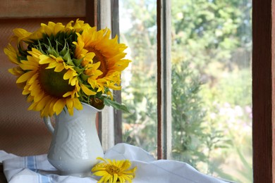 Beautiful sunflowers in vase near window indoors. Space for text
