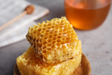 Photo of Fresh delicious honeycombs on grey table, closeup