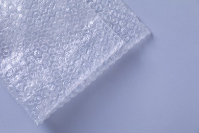 Photo of Transparent bubble wrap on gray background, top view. Space for text