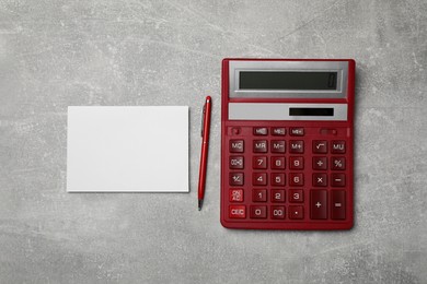 Calculator and office stationery on grey table, flat lay. Space for text