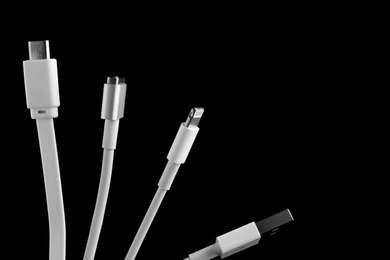 Photo of Charge cables on black background, closeup. Space for text