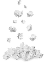 Crumpled paper falling into pile on white background