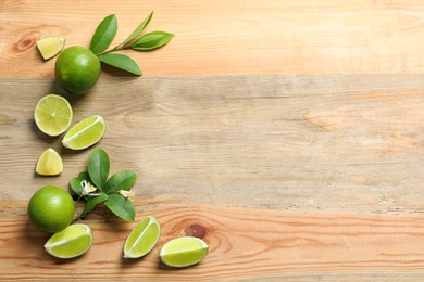 Photo of Composition with fresh ripe limes on wooden background, top view
