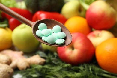 Dietary supplements in wooden spoon near products, closeup. Space for text