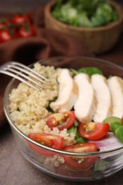 Photo of Delicious quinoa salad with chicken and cherry tomatoes served on grey textured table, closeup