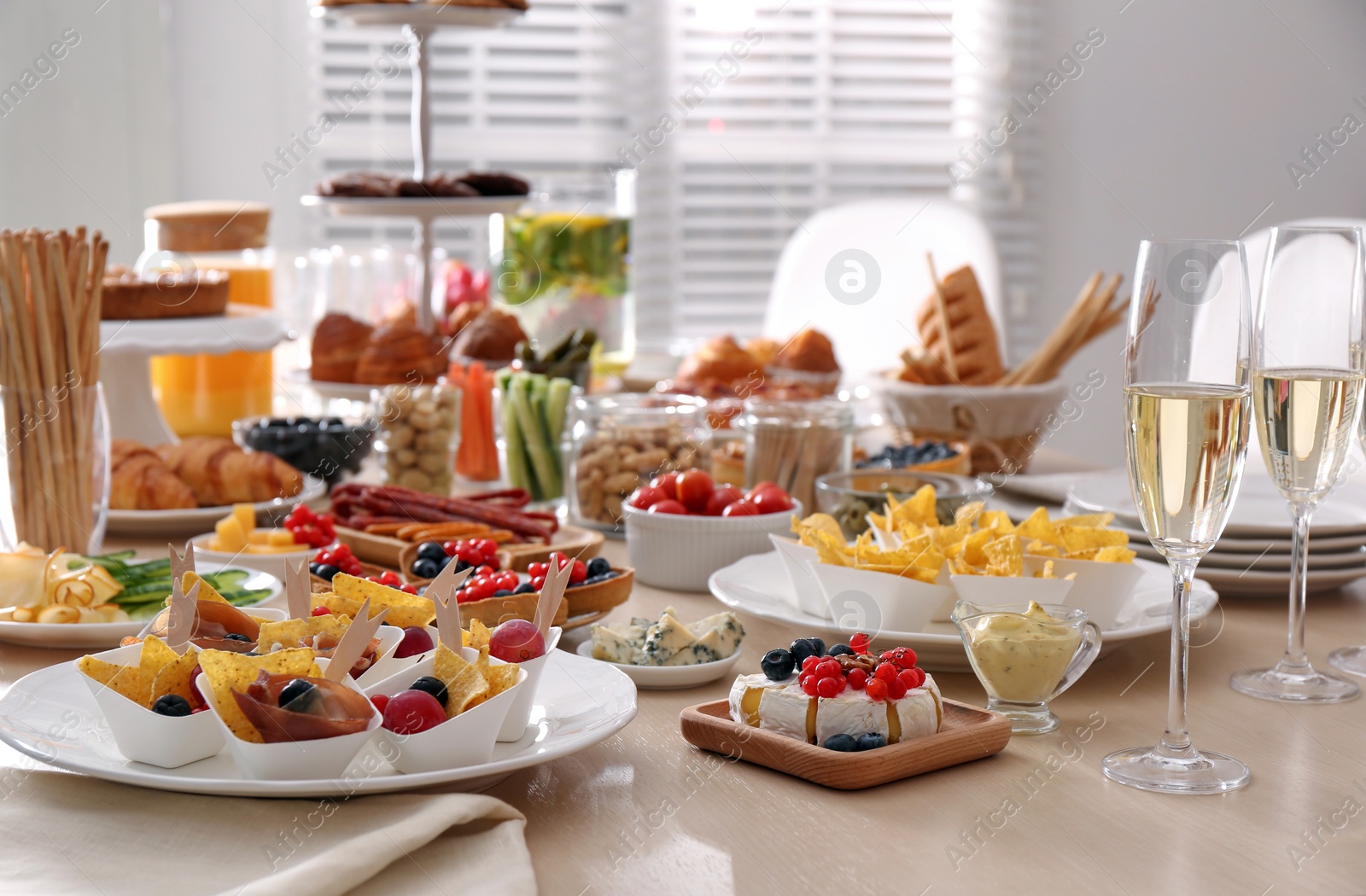 Photo of Variety of snacks on wooden table in buffet style indoors