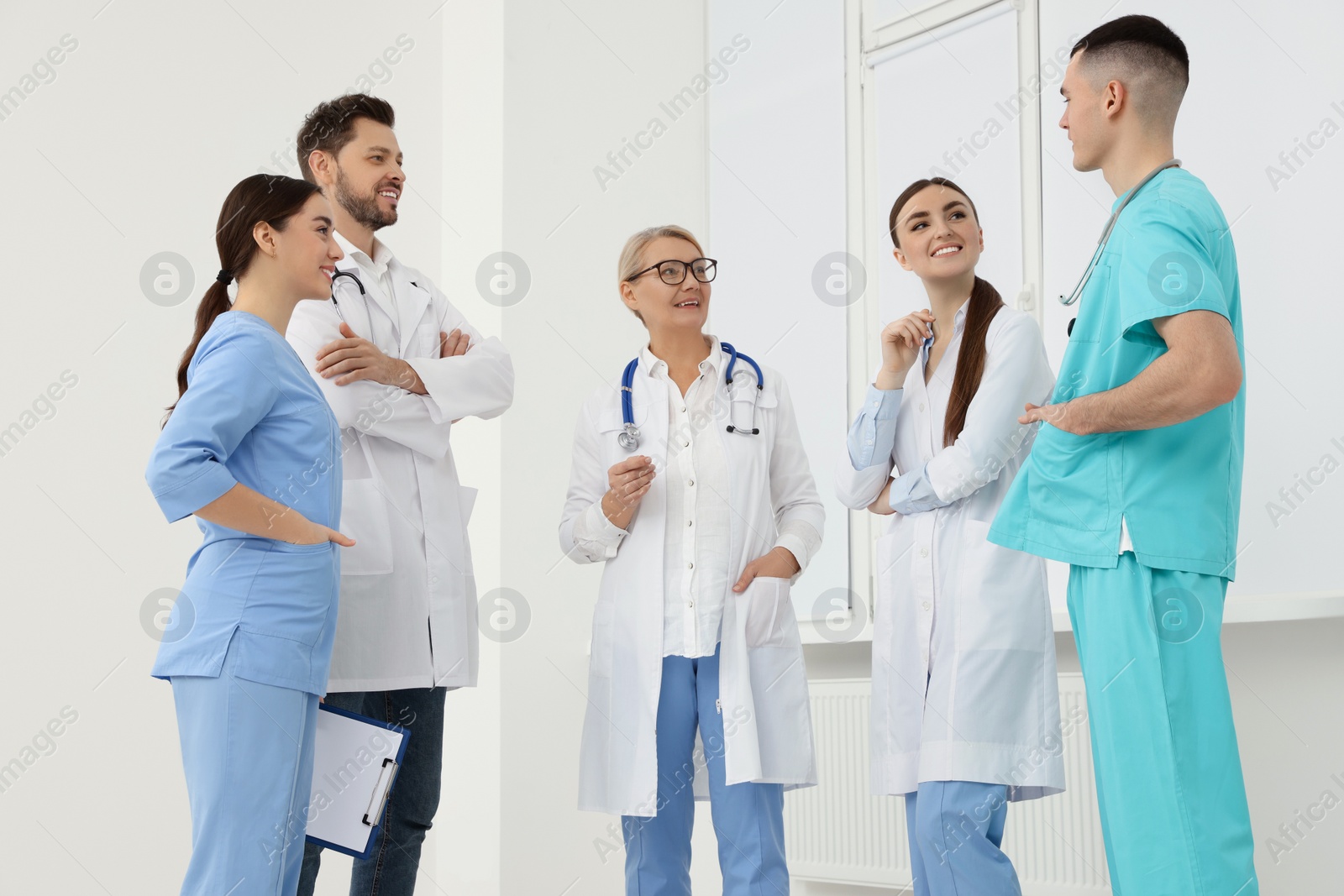 Photo of Medical doctors in uniforms having discussion in clinic