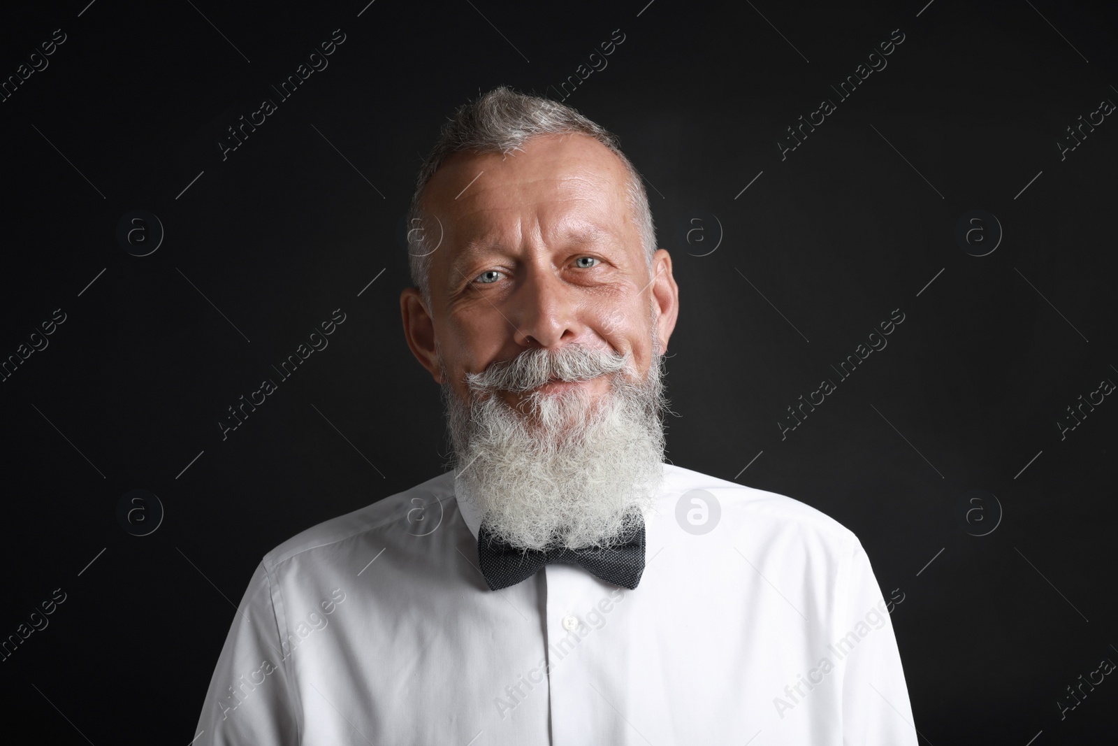 Photo of Portrait of handsome senior man on black background