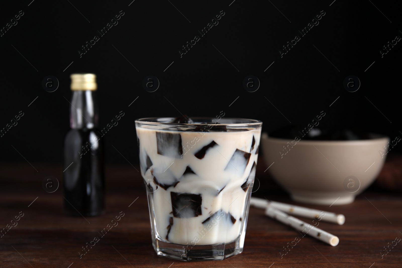 Photo of Glass of milk with grass jelly on wooden table