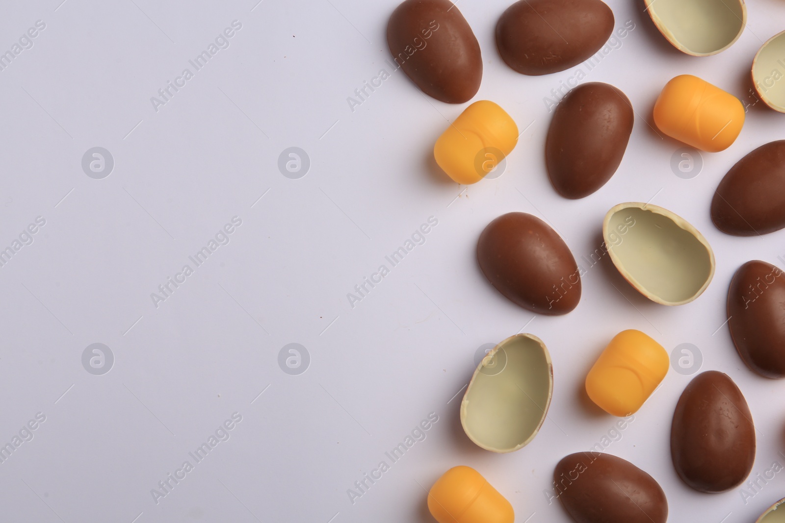 Photo of Sveti Vlas, Bulgaria - June 30, , 2023: Halves of Kinder Surprise Eggs and plastic capsules on white background, flat lay. Space for text