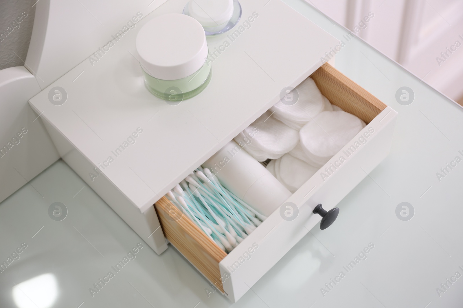 Photo of Drawer with cotton buds and pads in dressing table