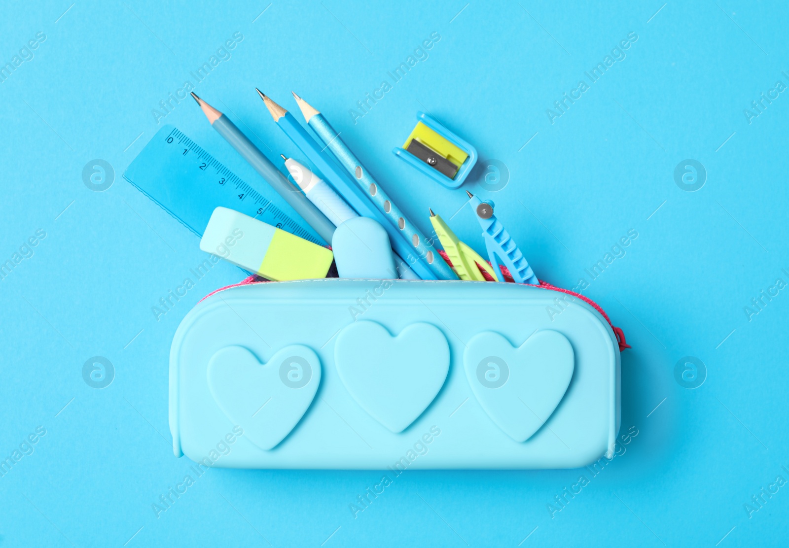 Photo of Pencil case and different stationery on light blue background, flat lay. Back to school