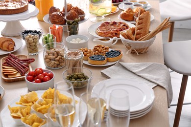 Photo of Variety of snacks on wooden table in buffet style indoors