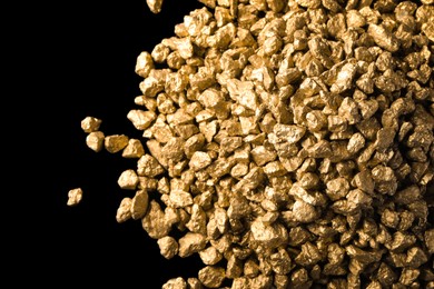 Photo of Pile of gold nuggets on black background, flat lay
