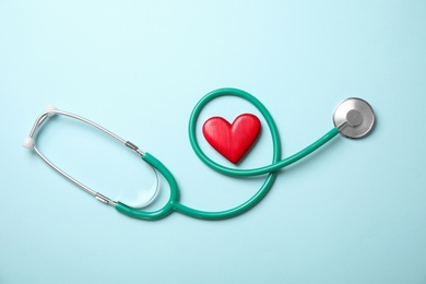 Stethoscope and red heart on color background, top view. Cardiology concept