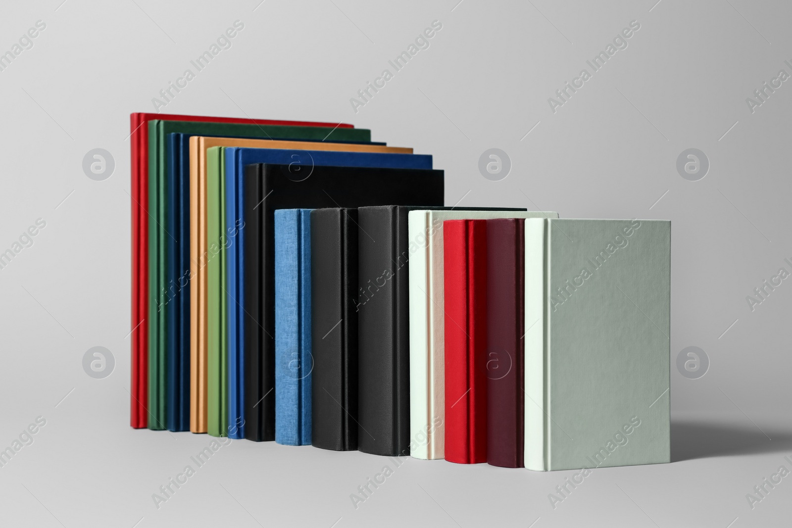 Photo of Many different hardcover books on light grey background