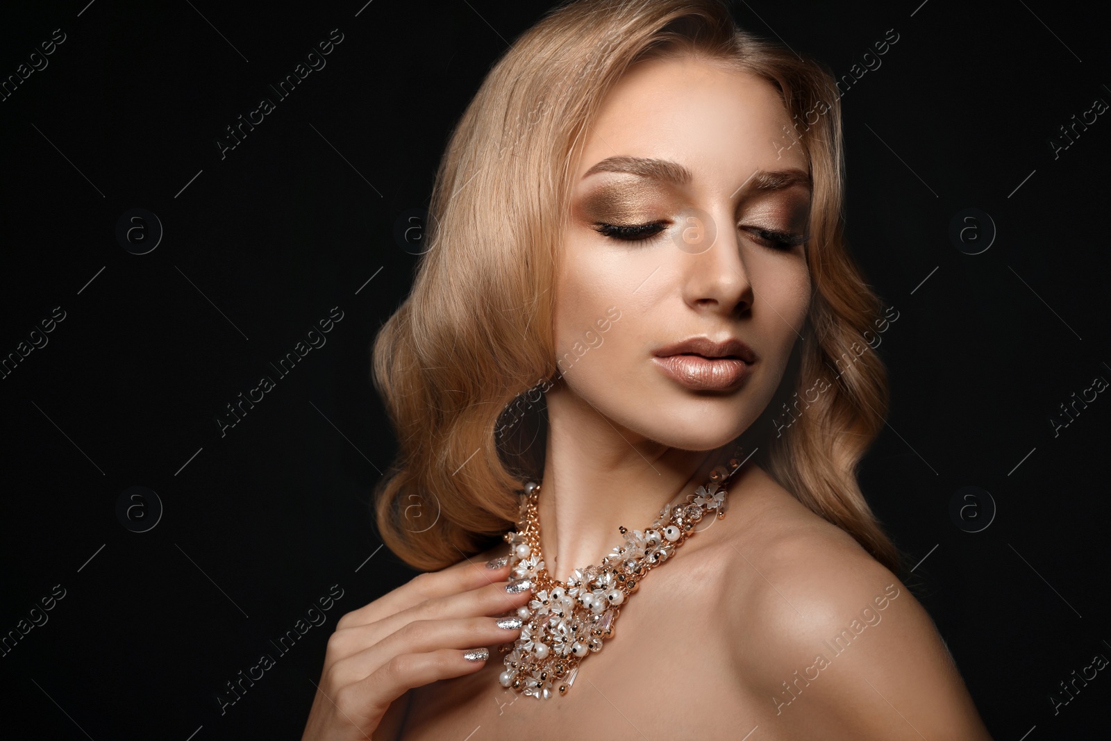 Photo of Beautiful young woman with elegant jewelry on dark background