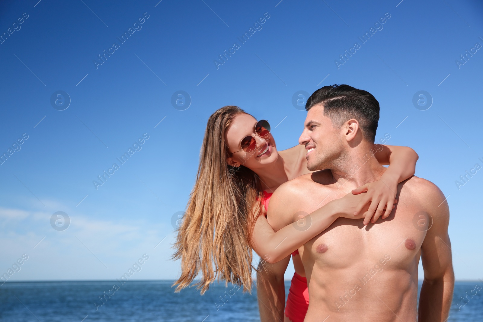 Photo of Beautiful woman and her boyfriend on beach. Happy couple